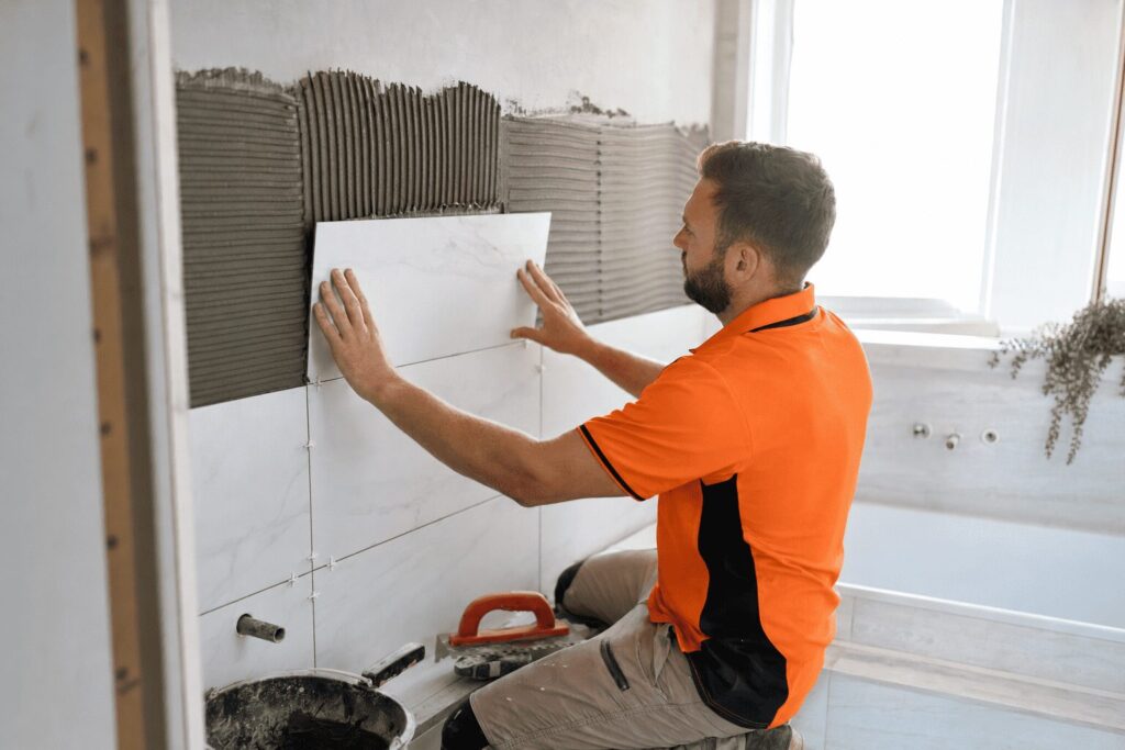 SBBM tradesman installing ceramic wall tiles in a Brisbane bathroom.